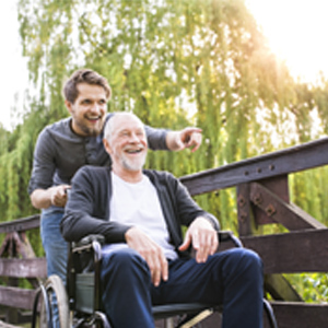 Financial Tips for Caregivers Son pushes elderly father in wheelchair