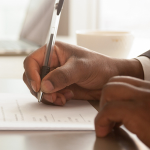 What Happens at a Mortgage Closing Man's hand signing mortgage documents